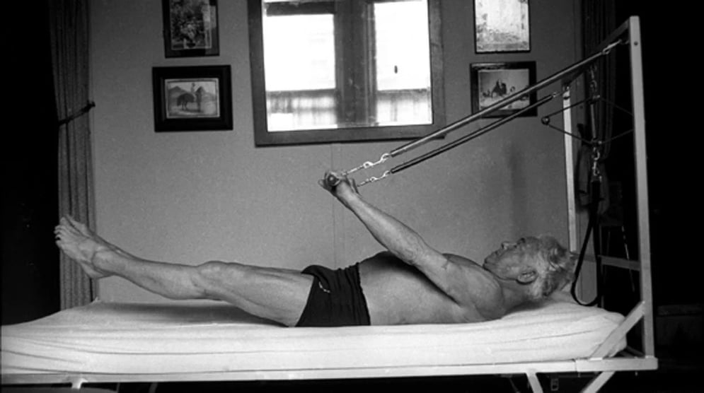 Joseph Pilates, haciendo uno de los ejercicios con muelles que el mismo se inventó
